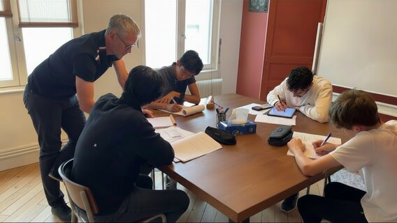 Photo de Vincent qui explique les maths à 4 collégiens studieux