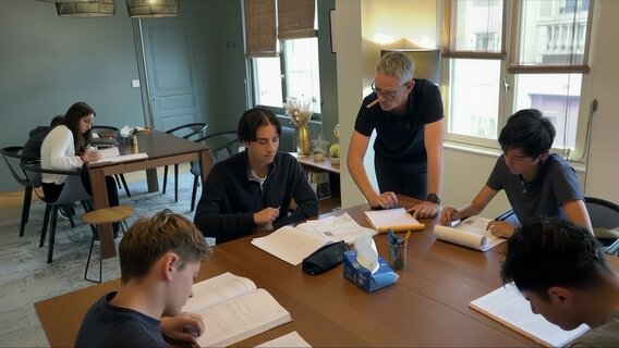 Photo de Vincent qui explique les maths à 4 collégiens studieux